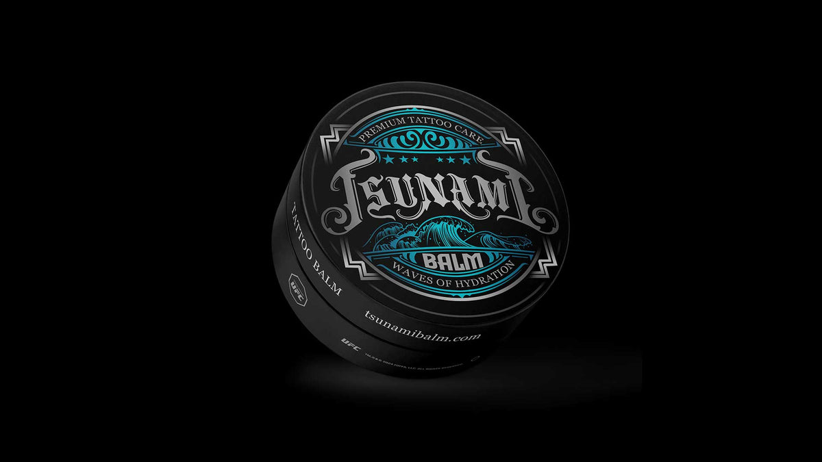 Tsunami Balm tattoo balm tin on a black background